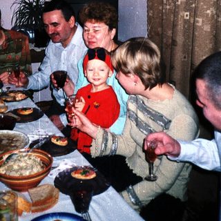 Family gathers for a meal with food and drinks.