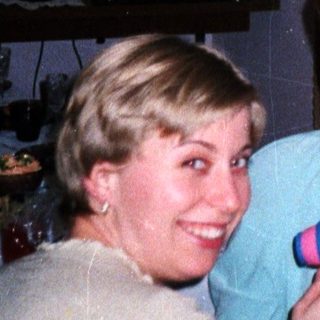 Woman styling hair with a child and another woman present.