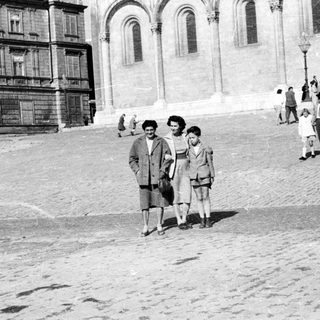 Black and white photo of people standing in front of a building.