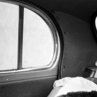 Man lies injured in a bed, covered with blankets.
