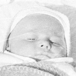 Infant sleeps peacefully in a vintage crib.
