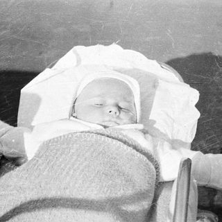 Infant sleeps peacefully in a vintage crib.