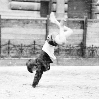 Man performing a flip in front of a building.