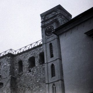 Stone building with clock tower and flag.
