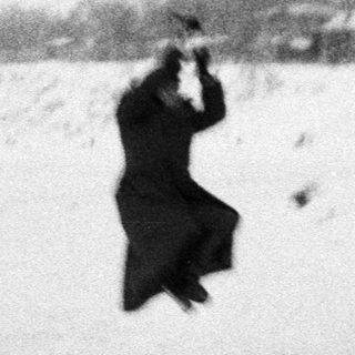 Man appears to be airborne in snowy landscape.