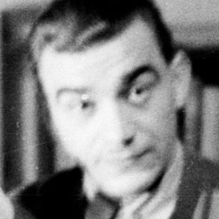 Man holding a statuette in a vintage black and white photo.