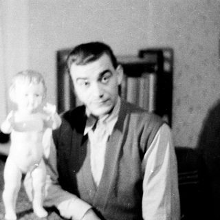 Man holding a statuette in a vintage black and white photo.