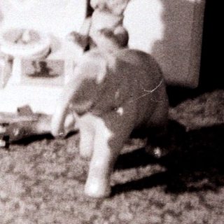 Figurines near a vintage record player on a textured floor.