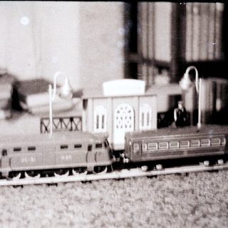 Model train set with building and track displayed.