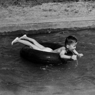 Boy floats on an inner tube in the ocean.