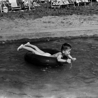 Boy floats on an inner tube in the ocean.