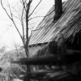 Flooding submerges landscape; structure partially visible along water's edge.