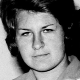 Woman in a classroom setting, looking directly at the camera.