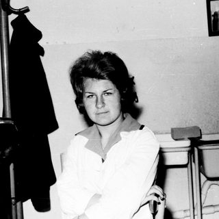 Woman in a classroom setting, looking directly at the camera.