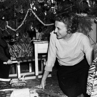 A woman and child play with a toy train.