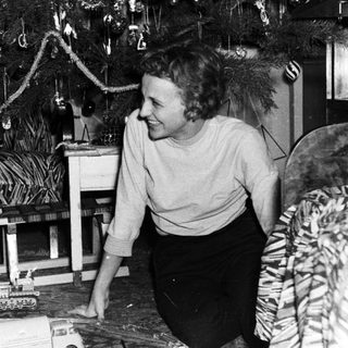A woman and child play with a toy train.
