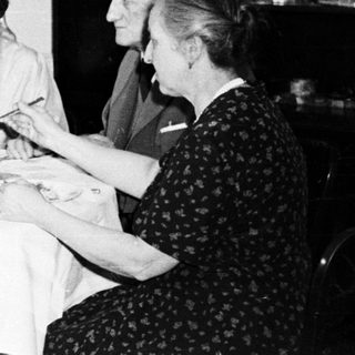 Here's a brief summary of the image: Four people seated at a table, seemingly having a meal.