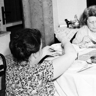 Family members seated at a table, eating a meal.