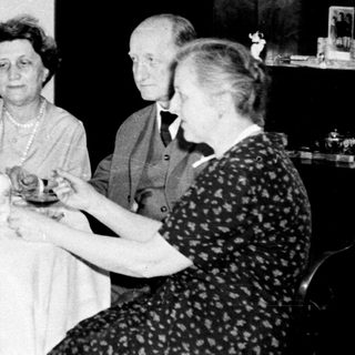 Black and white photo of four people seated at a table.