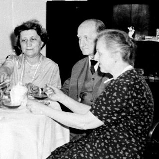 Black and white photo of four people seated at a table.