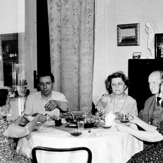 Black and white photo of four people seated at a table.