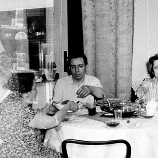 Black and white photo of four people seated at a table.