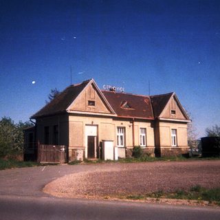 Old, small train station building under a dark sky.