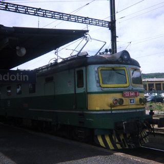 Locomotive stands on tracks under a station platform.