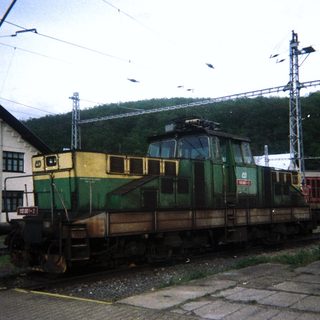 Green and yellow locomotive sits on a railway track.