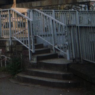 Underpass and railway infrastructure with graffiti and construction.