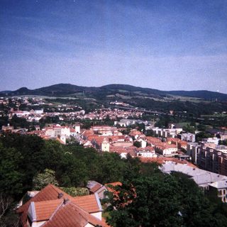 Aerial view of a town nestled among green hills.