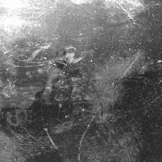 Close-up of a textured, dark surface with scratches and marks.