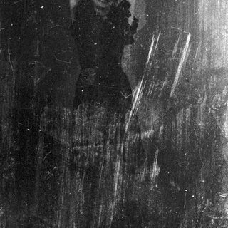 Faded, damaged image appears to show a person standing.