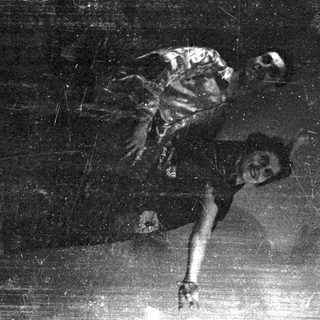 Here's a brief summary: Two figures appear to be dancing in a dimly lit space.