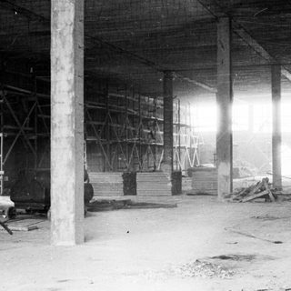 Here's a brief summary of the image: Interior of a construction site with lumber and scaffolding.