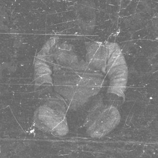 Here's a brief summary of the image: Fragment of film showing a hand and part of an arm.