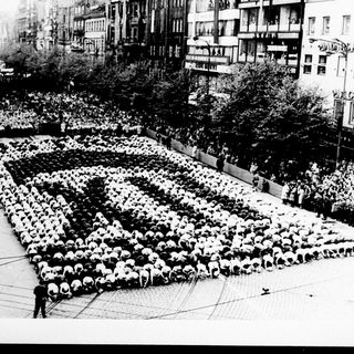 People arranged in a formation, creating a large design.