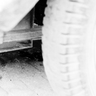 Tire and car undercarriage visible on a paved surface.