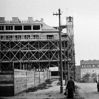 Construction, tram, and pedestrian on a street scene.