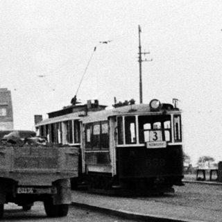 Construction, tram, and pedestrian on a street scene.