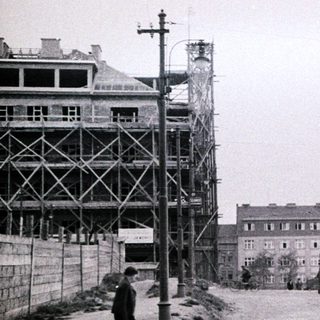 Black and white image of a street with construction and tram.