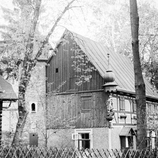 Black and white image of a timber-framed building.