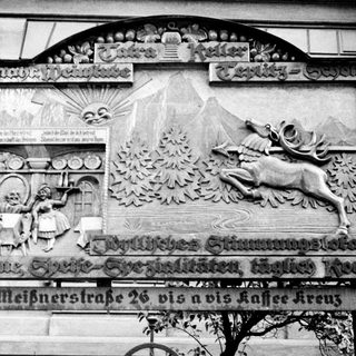 Highly decorated building facade with relief carvings and signage.