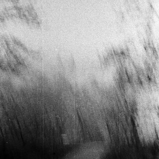 Dark, grainy image with indistinct shapes and light patterns.