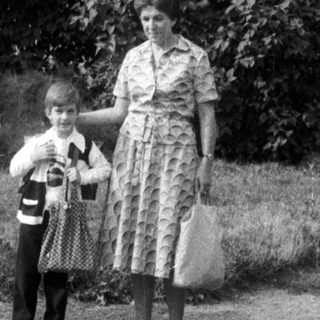 Black and white photo of a woman and child standing outside.
