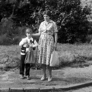 Black and white photo of a woman and child standing outside.