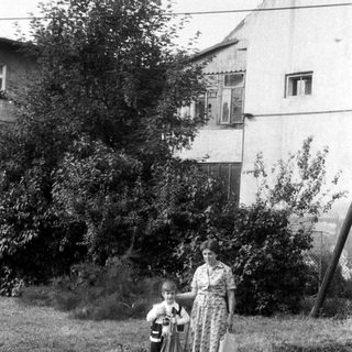 Black and white photo of a woman and child standing outside.