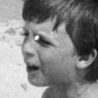 Boy playing in a sand hole at the beach.