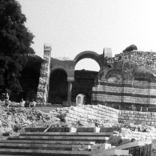 Ruined stone staircase leading to a crumbling archway.