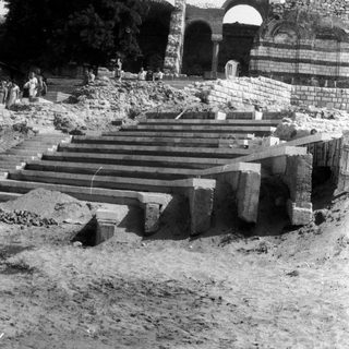 Ruined stone staircase leading to a crumbling archway.